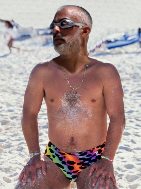 Persona en la playa con gafas de natación y bañador estampado